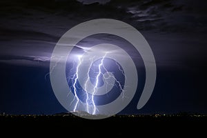 Thunderstorm with lightning bolt strikes and storm clouds over a city