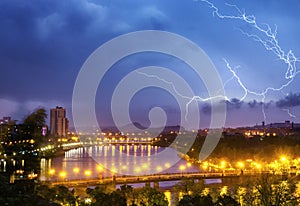 Thunderstorm with lightning over night city sky.