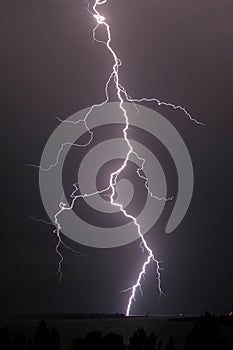 Thunderstorm and lightning strike over the river at night