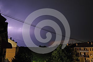 Thunderstorm at night over the city. Flashes of lightning and low clouds. Thunder and lightning. Natural element