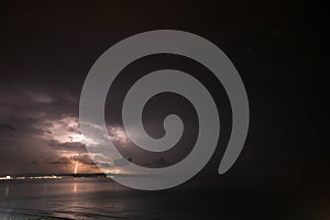 Thunderstorm over the sea, lightning beats the water