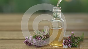 Thyme essential oil in  beautiful bottle on table