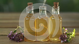 Thyme essential oil in  beautiful bottle on table