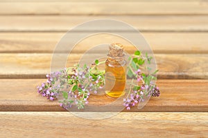 Thyme essential oil in  beautiful bottle on table