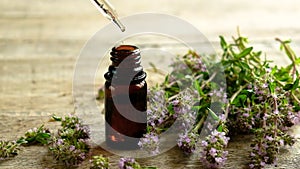 Thyme essential oil in a small bottle. Selective focus.