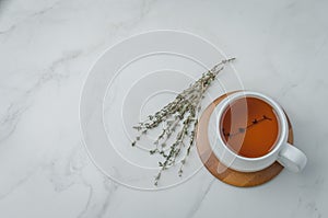 Thyme herbal tea in a white cup on a bamboo support. Copyspace and top view