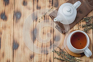 Thyme herbal tea, White cup with tea and kettle. Top view and copyspace