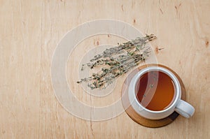 Thyme herbal tea on a wooden table, top view, space for a text