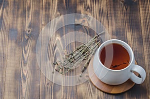 Thyme herbal tea on a wooden table, top view, space for a text