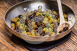 Thyme and olives in a skillet