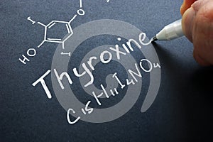 Thyroxine hormone sign on a black paper