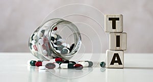 TIA Transient Ischemic Attack - acronym on cubes on a light background with a capacity with tablets