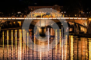 Tiber River, bridge and reflections on water. Night Rome, Italy.