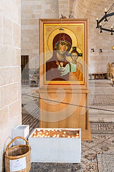 Lighted candles in front of the Icon of the Virgin and Child in the central hall in Tabgha - Catholic Church Multiplication of bre