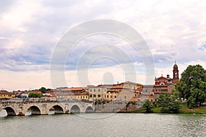 Tiberius bridge and old town buildings cityscape in Rimini