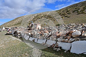 Tibet. Ancient stupas and buddhist prayer stones with mantras and ritual drawings on the trail from the town of Dorchen around mou