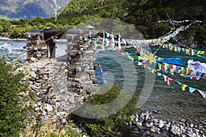 Tibet: rope bridge with prayer flags