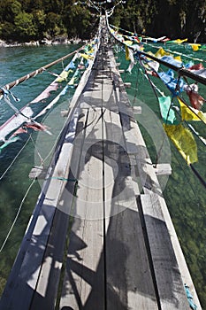 Tibet: rope bridge with prayer flags
