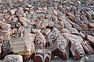 Tibet. Whate stupa and buddhist prayer stones with mantras and ritual drawings on the trail from the town of Dorchen around mount