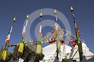 A Tibetan Buddhist colored prayer flags on the background of the temple of the Bodnath stupa and clear blue sky
