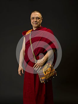 Tibetan Buddhist monk teacher in a burgundy yellow outfit suit