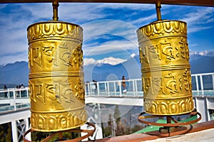 Tibetan Buddhist Prayer wheel with blur background of mountain landscape