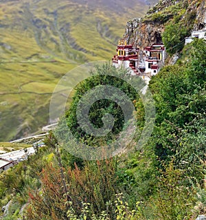 Tibetan Drak Yerpa Buddhist monastery on the cliff in Mountains of Tibet. The Holiest caves for meditation and place for pilgrim photo