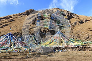 Tibetan landscape in China with prayer flags on foreground and mountains on background