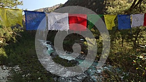 Tibetan prayer flags hanging with river flowing in background