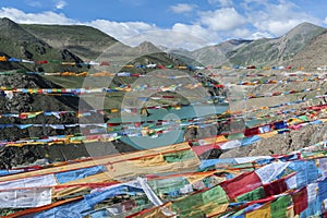 Tibetan prayer flags in the hydroelectric Yamdrok-tso lake at Sim or Simu La pass, along Southern Friendship Highway, Tibet.