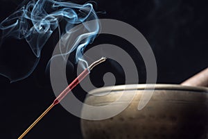 Tibetan singing bowl and incense sticks burning with smoke