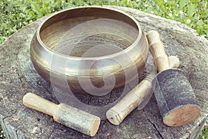 Tibetan Singing bowl with mallets on a wooden backgroung