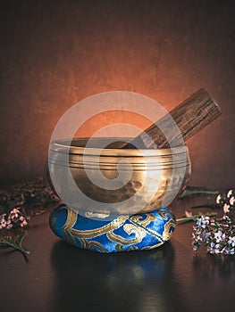 Tibetan singing bowl on ring cushion with golden light in the background