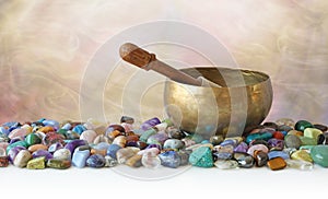 Tibetan Singing Bowl surrounded by tumbled healing stones