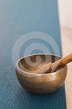 Tibetan singing bowl on a turquoise yoga mat