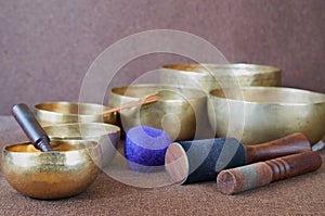 Tibetan singing bowls with sticks on the brown cloth background - music instruments for meditation, relaxation after yoga practice