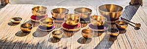 Tibetan singing bowls on a straw mat against a waterfall BANNER, LONG FORMAT