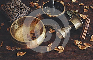Tibetan themed close up with examples of two different singing bowls - a dark brown, and gold colored one