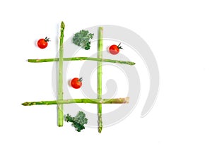 Tic tac toe with food, asparagus kale, tomato, top view