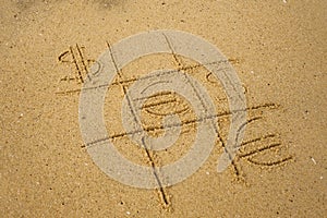 Tic-tac-toe game with playing euro and dollar symbols on sand.