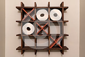 A Tic-Tac-Toe wooden shelf for rolls of toilet paper. Toilet decoration.