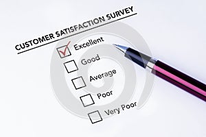 Tick placed in excellent check box on customer service satisfaction survey form with a pen on isolated white background. Business