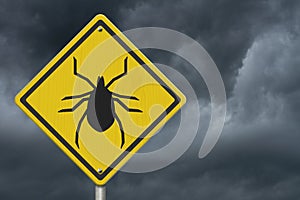 Tick warning on a on yellow highway caution road sign