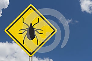 Tick warning on a on yellow highway caution road sign