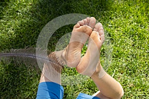 tickle the child s bare feet with a large ostrich feather