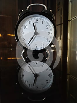 Tickling clock on the table and its refelction