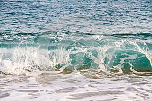 Tidal bore. Blue waves with bats rolling onto a sandy beach