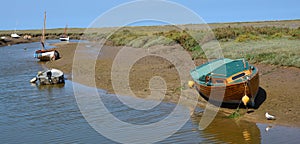 Tidal creek between at Morston Quay at low tide with boats