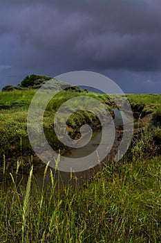 Tidal creek with stormy sky