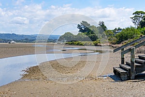 Tidal stream across wetland mudflats at Matua